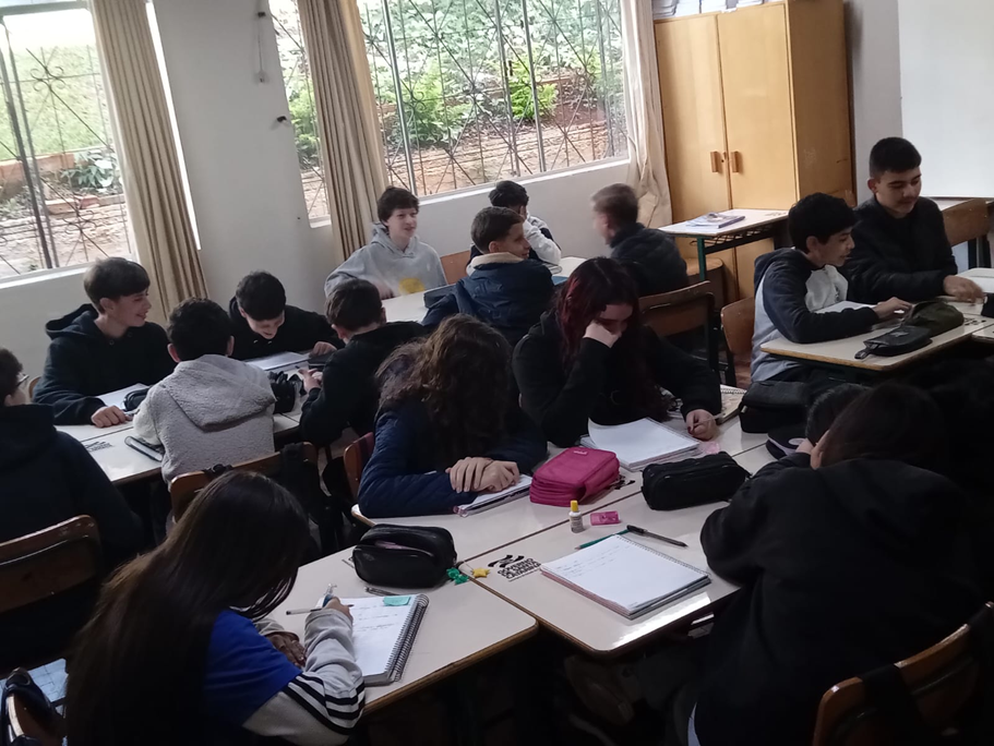 Turma do 8º ano reunida em duplas e trios, escrevendo a produção textual