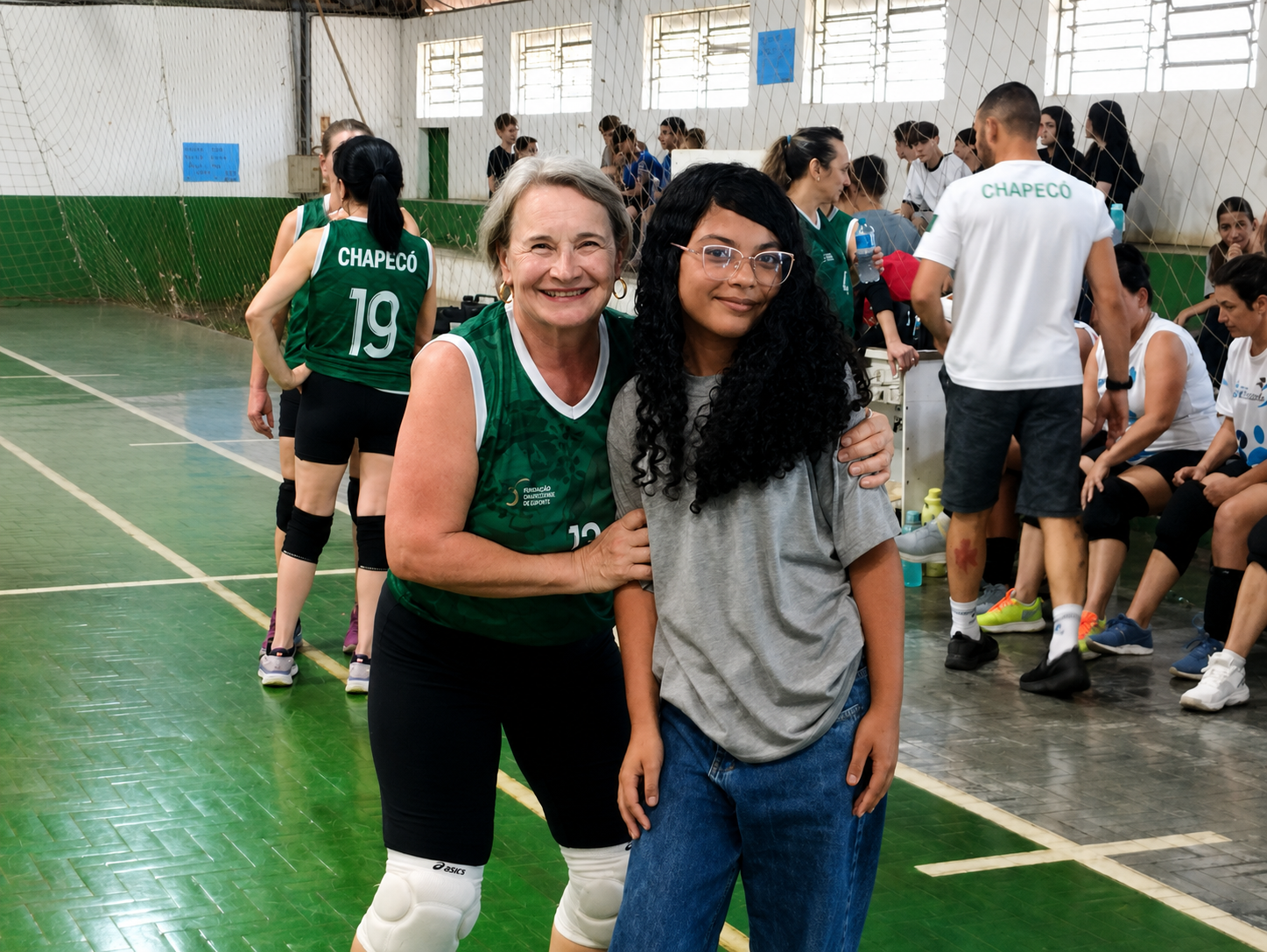 Aluna e atleta da terceira idade posando juntas na quadra